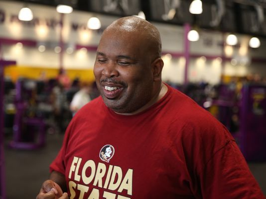 Walter Blackmon wearing a Florida State University t-shirt smiling while standing in the middle of a gym.